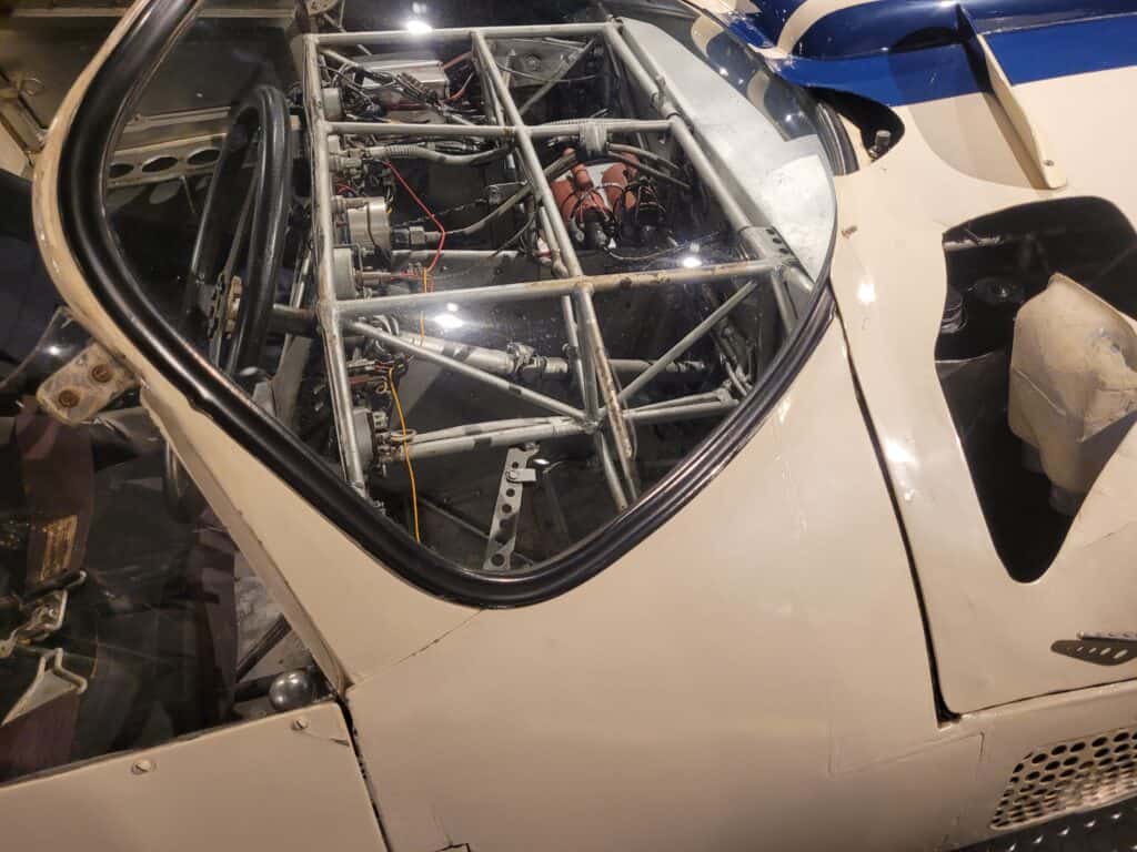 A white Maserati Birdcage racing car in a museum