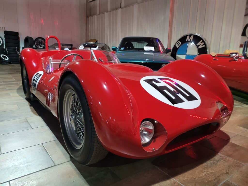 A red Maserati Birdcage racing car in a museum