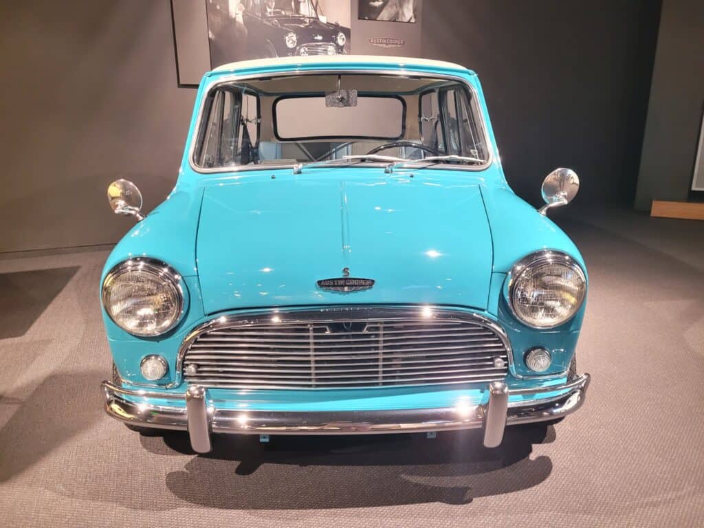 front of sky-blue Mini Cooper